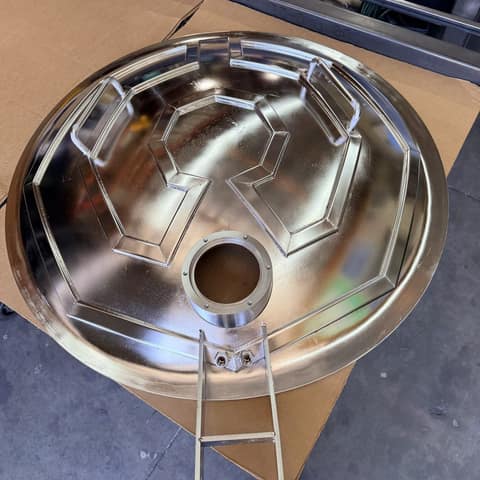 Mirror-polished stainless steel dish with welded handles and a machined port