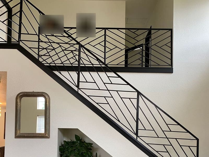 After: the same stair with a new black steel railing in a geometric diagonal bar pattern.